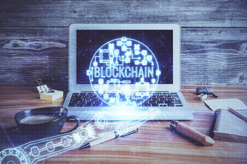 Multi exposure of blockchain and crypto economy theme hologram and table with computer background....