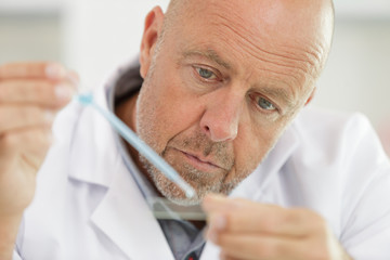 close view of senior male scientist using pipette