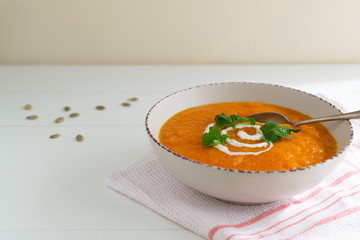 Pumpkin and carrot soup with sour cream and parsley. Vegetarian soup. Healthy eating concept.