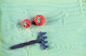 
two decorative pumpkins and rakes lie on a green background