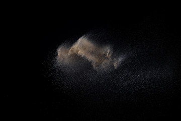 Sandy explosion isolated on black background. Abstract particles cloud. Texture element for design.