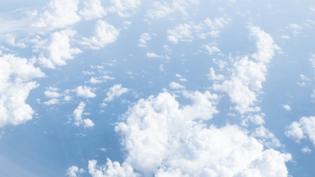 Blue sky and white clouds view looking through airplane window. Travel, vacation and journey concept.Soft focus, Select focus. Panorama image.