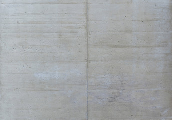 A grey beige freshly poured concrete wall with slight traces of form work