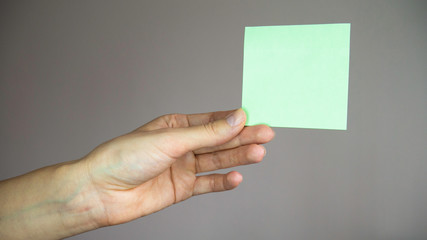 Fototapeta premium Square paper with space for text in the hand. 