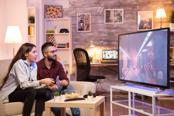 Relaxed girlfriend playing video games on television © DC Studio