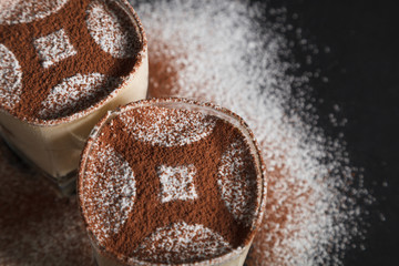 Traditional italian dessert tiramisu on glass on the black background