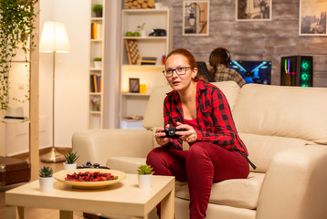 Woman gamer playing video games on the console in the living room