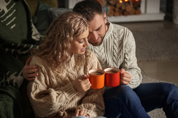 Happy young couple drinking hot cocoa at home