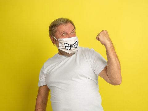 Celebrating Winner. Portrait Of Caucasian Senior Man With Emotion On His Protective Face Mask Isolated On Studio Background. Beautiful Male Model. Human Emotions, Facial Expression, Sales, Ad Concept.