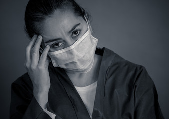 Female doctor feeling exhausted after long shift treating coronavirus infected patients at hospital