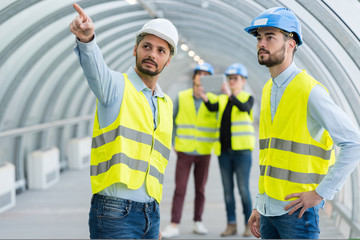 portrait of engineer points at construction