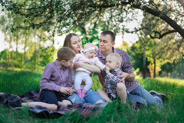 Fototapeta premium Happy family having picnic in nature. Concept candid family and 3 children in family