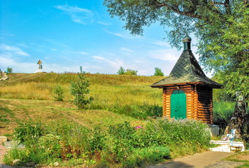 Fototapeta na wymiar Small log chapel at holy spring White Well