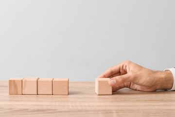 Man removing wooden cube from table. Concept of dismissal