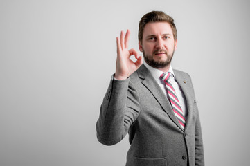 Portrait of business man wearing business clothes showing ok gesture