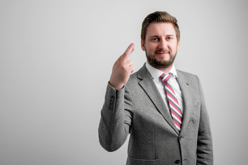 Portrait of business man wearing business clothes showing fingers crossed