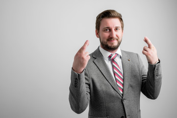Portrait of business man wearing business clothes showing double fingers crossed