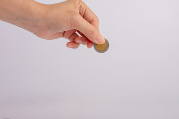 A female(woman) hand hold a coin isolated white background. Close-up