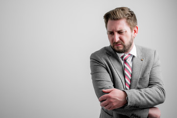 Portrait of business man wearing business clothes gesturing elbow ache
