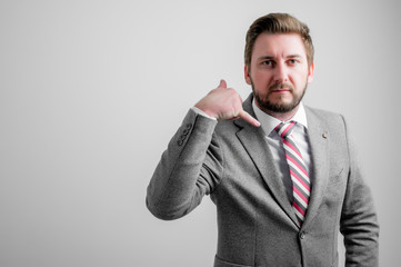 Portrait of business man wearing business clothes showing calling or contact gesture