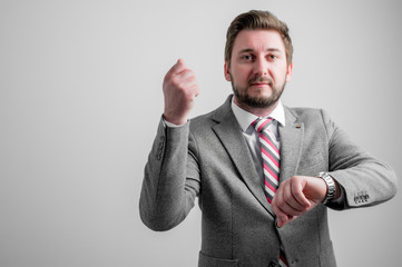 Portrait of business man wearing business clothes showing time is money gesture
