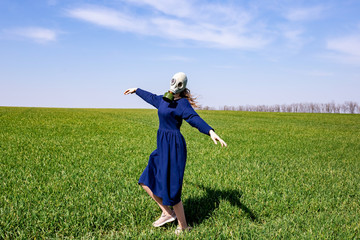 Gas mask on the face of a young girl. A young girl in the middle of a green field.