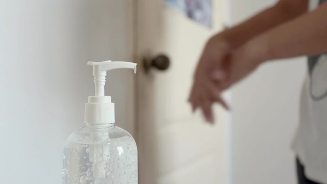 Coronavirus sanitiser gel for clean hands hygiene corona virus spread prevention. Man using alcohol rub alternative to washing hands before leaving from his room.
