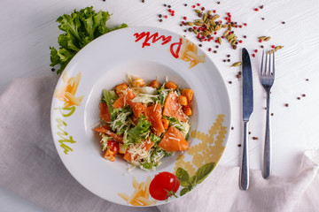 Caesar salad with salmon salad leaves on a light background, menu