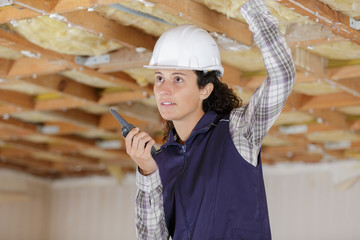 a woman uses a walkie inside construction