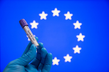 Corona virus or Covid-19 in European union, sample blood tube in hand with European union flag on background