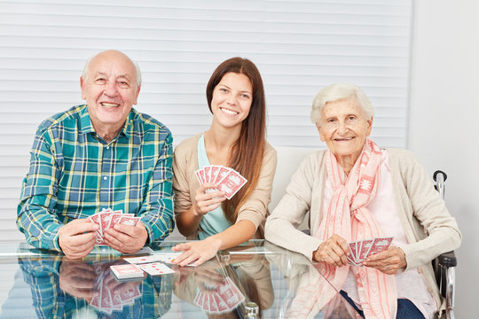 Paar Senioren beim Karten spielen mit Tochter