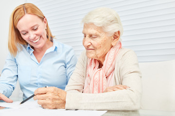 Seniorin bei Finanzberatung liest Vertrag