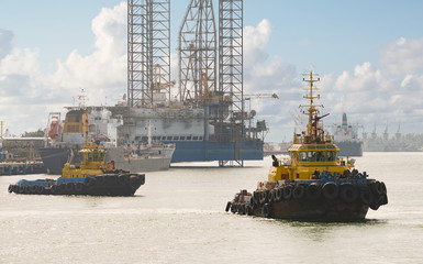 Tug boats awaiting big cargo ship in harbour for tug assistance, maneuvering, mooring operations....
