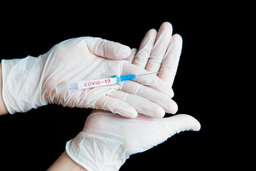 Hands in white gloves hold a syringe on a blue background. Coronavirus disinfectants, asian flu outbreak, Coronavirus 2019-nCoV, Corona virus outbreaking. Spray bottle