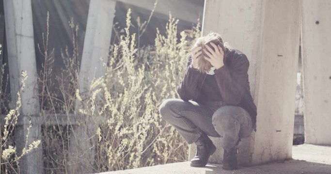 Woman with face mask full of anxiety fear agony and depression have mental breakdown at an empty space closed for safety isolation and social distance due to coronavirus covid 19 pandemic outbreak