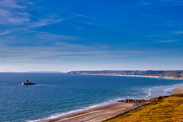Obraz premium Image of St Ouens Bay looking North with La Rocco Tower and the shoreline. Jersey, Channel Islands