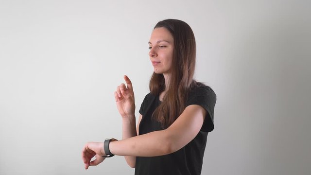 Young woman in studio using her smart watch with hologram, extendent reality, AR. Mock up