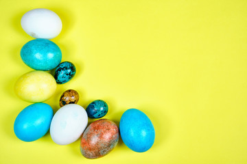 Multicolored, painted Easter eggs on a yellow background. space for text
