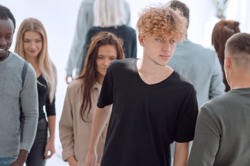 serious woman standing in front of casual group of young people