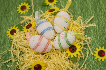 Colorful beautiful eggs on a green background with yellow flowers for the bright holiday of Easter