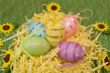Colorful beautiful eggs on a green background with yellow flowers for the bright holiday of Easter