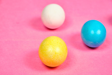 Multicolored, painted Easter eggs on a pink background. space for text