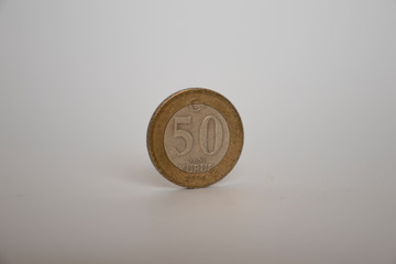 COIN FIFTY YENI KURUS STANDS VERTICALLY ON THE WHITE BACKGROUND.