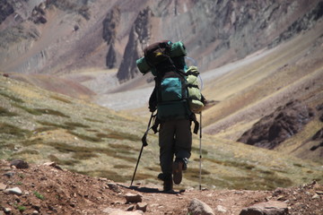 samotny turysta z dużym plecakiem na górskim szlaku