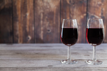  two red wine glasses  on wooden