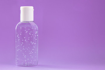 A bottle of hand sanitizer gel. Hand hygiene as coronavirus protection. Antivirus and antibacterial product. Purple liquid with white round granules. Copy space for text
