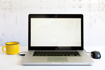 laptop with mouse and yellow cup
