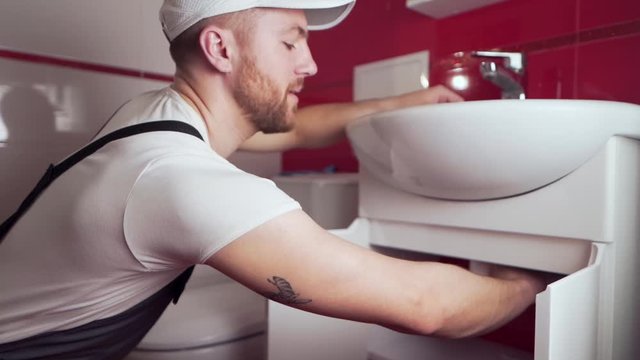 the plumber in working form shows a thumbs up that everything will be done