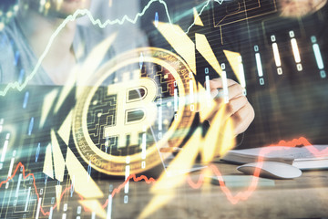 Crypto currency theme hologram with businessman working on computer on background. Concept of...