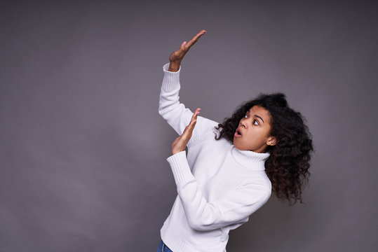 A young dark-skinned girl scaredly raised her hands up.